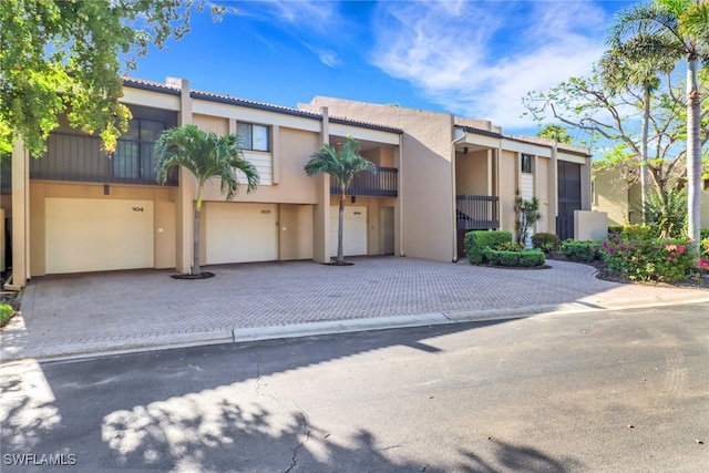 5015 Harbortown Ln Unit 204, Fort Myers, FL 33919 - view of property featuring a garage, decorative driveway, stucco siding, and a tile roof