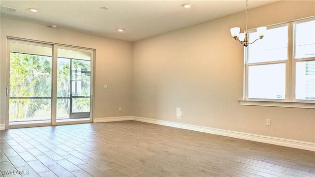 986 Enbrook Loop, Naples, FL 34114 - unfurnished room featuring baseboards, plenty of natural light, a chandelier, wood finished floors, and recessed lighting