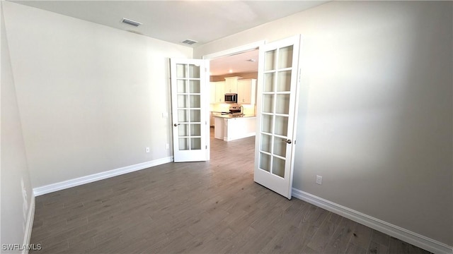 986 Enbrook Loop, Naples, FL 34114 - empty room with french doors, dark wood-style flooring, and baseboards