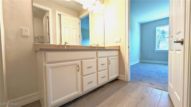 986 Enbrook Loop, Naples, FL 34114 - bathroom with baseboards, double vanity, and wood finished floors