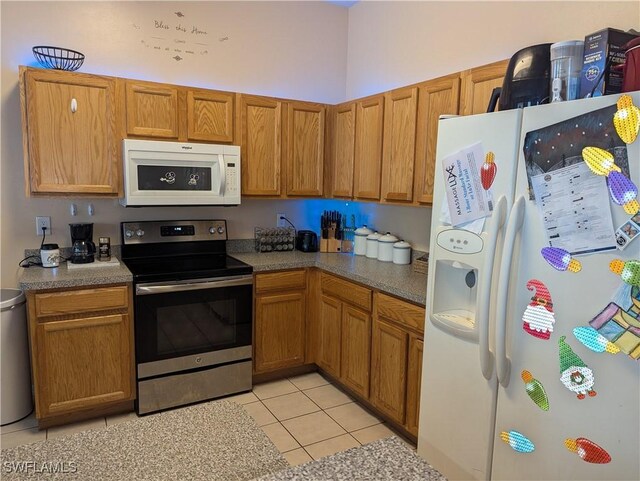 2543 Nature Pointe Loop, Fort Myers, FL 33905 - kitchen with white appliances, light tile patterned floors, and brown cabinets