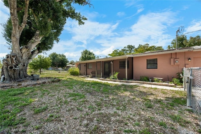 7384 Coon Rd, North Fort Myers, FL 33917 - rear view of property featuring stucco siding and a sunroom