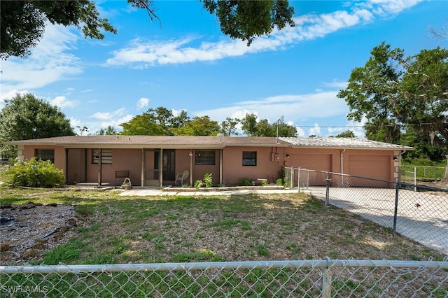 7384 Coon Rd, North Fort Myers, FL 33917 - ranch-style house with a garage, fence, stucco siding, and driveway