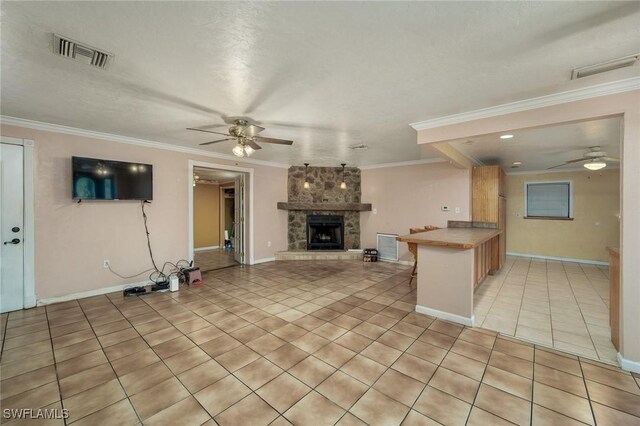 7384 Coon Rd, North Fort Myers, FL 33917 - unfurnished living room featuring a ceiling fan, light tile patterned floors, a stone fireplace, crown molding, and baseboards