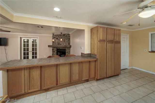 7384 Coon Rd, North Fort Myers, FL 33917 - kitchen featuring ceiling fan, tile counters, brown cabinetry, french doors, and crown molding