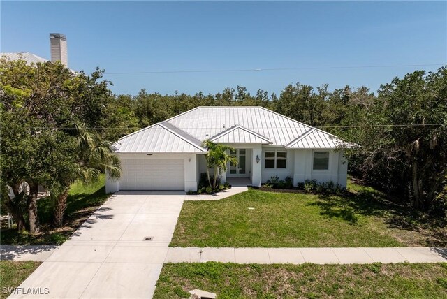 1923 Sheffield Ave, Marco Island, FL 34145 - view of front of property with a garage, driveway, a front lawn, a standing seam roof, and stucco siding