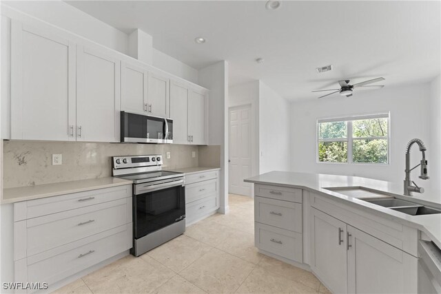 1923 Sheffield Ave, Marco Island, FL 34145 - kitchen with stainless steel appliances, a sink, backsplash, a ceiling fan, and light countertops