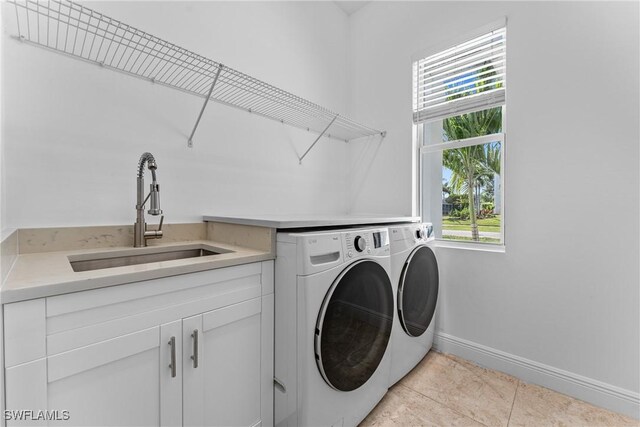1923 Sheffield Ave, Marco Island, FL 34145 - washroom featuring washing machine and dryer, baseboards, cabinet space, and light tile patterned flooring