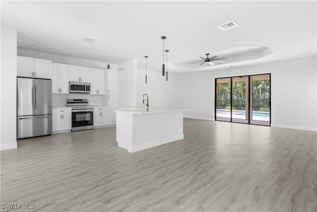 2208 SW 12th Ln, Cape Coral, FL 33991 - unfurnished living room with ceiling fan, light wood-style flooring, baseboards, and a tray ceiling