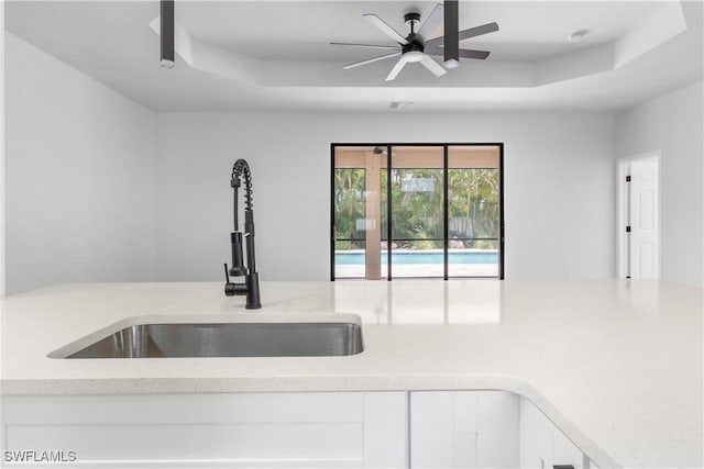 2208 SW 12th Ln, Cape Coral, FL 33991 - kitchen featuring a sink, white cabinets, ceiling fan, and light stone counters
