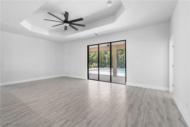2208 SW 12th Ln, Cape Coral, FL 33991 - unfurnished room featuring a raised ceiling, light wood-style flooring, baseboards, and ceiling fan
