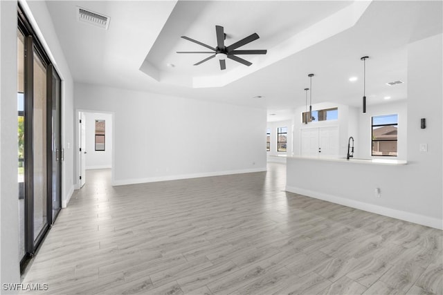 2208 SW 12th Ln, Cape Coral, FL 33991 - unfurnished living room with a raised ceiling, a ceiling fan, light wood-style flooring, baseboards, and recessed lighting