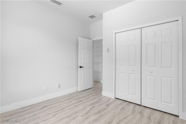 2208 SW 12th Ln, Cape Coral, FL 33991 - unfurnished bedroom with baseboards, a closet, and wood finished floors