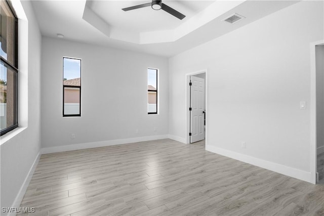 2208 SW 12th Ln, Cape Coral, FL 33991 - empty room with healthy amount of natural light, ceiling fan, a raised ceiling, and light wood-style floors