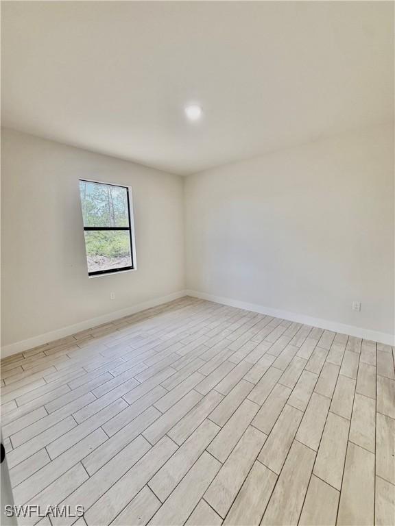 3411 74th St W, Lehigh Acres, FL 33971 - unfurnished room with light wood-style flooring, baseboards, and recessed lighting