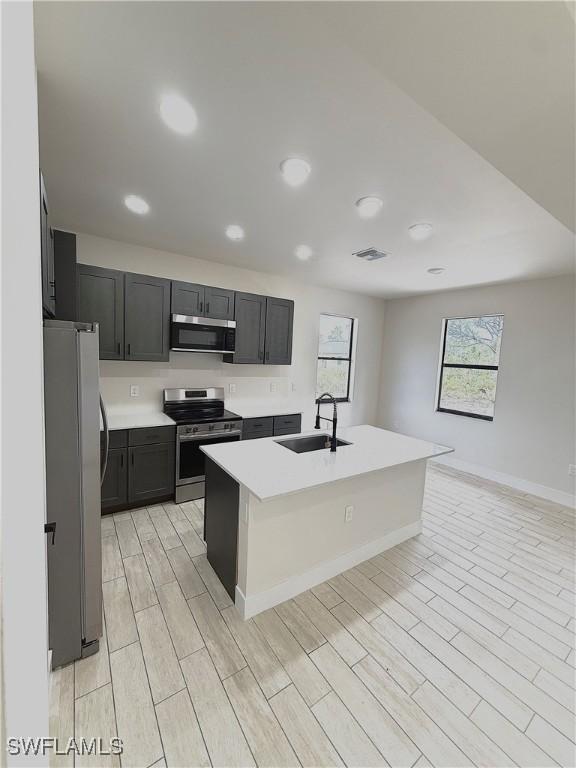 3411 74th St W, Lehigh Acres, FL 33971 - kitchen with stainless steel appliances, a sink, healthy amount of natural light, light countertops, and recessed lighting