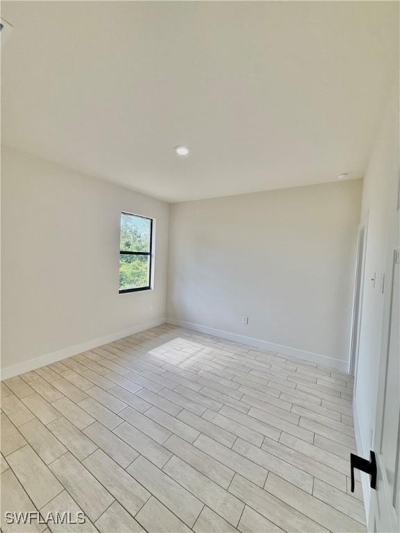 3411 74th St W, Lehigh Acres, FL 33971 - unfurnished room with baseboards and recessed lighting