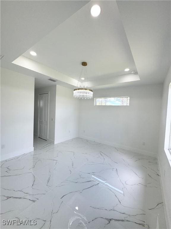 1010 Euclid Ave, Lehigh Acres, FL 33972 - spare room featuring a raised ceiling, baseboards, recessed lighting, and a chandelier