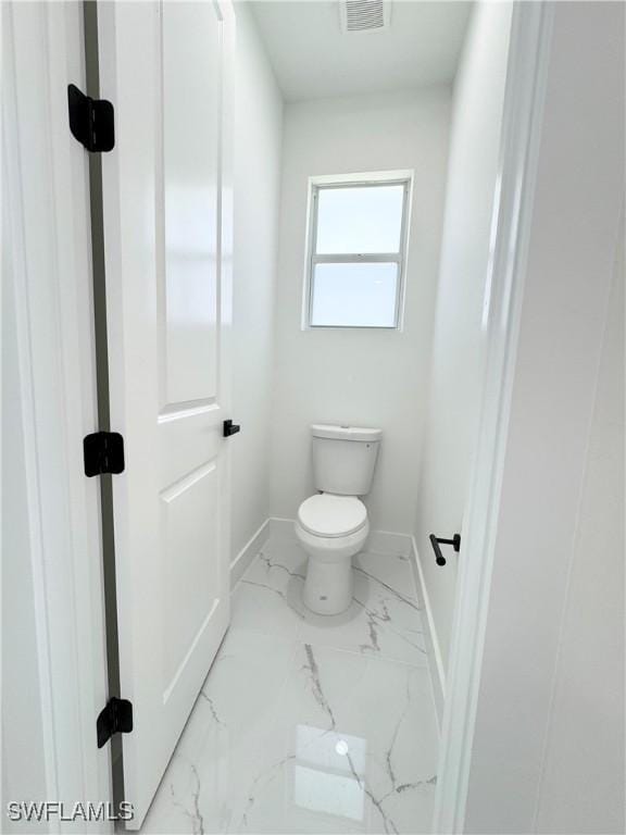 1010 Euclid Ave, Lehigh Acres, FL 33972 - bathroom with baseboards, marble finish flooring, and toilet