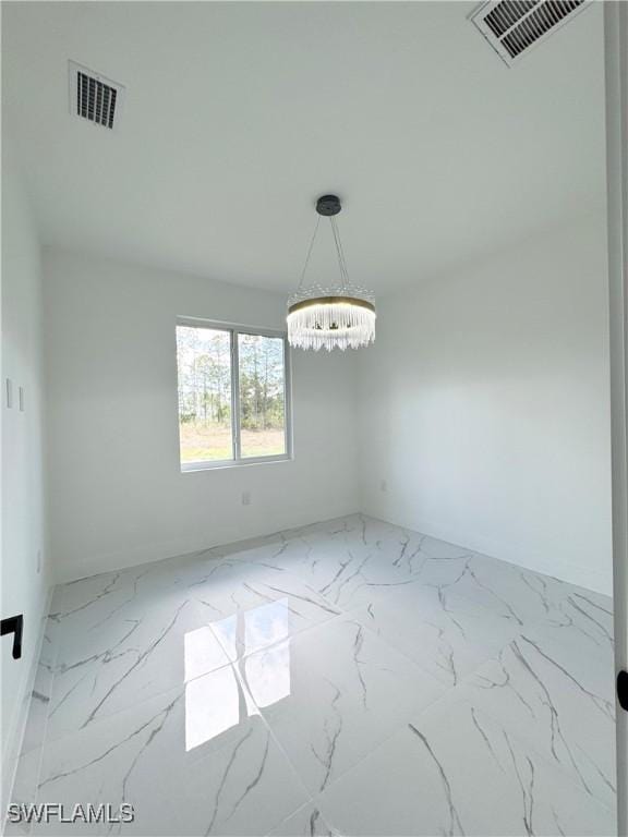 1010 Euclid Ave, Lehigh Acres, FL 33972 - empty room with marble look tiles and a chandelier
