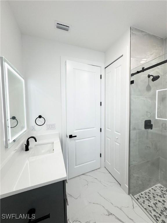 1010 Euclid Ave, Lehigh Acres, FL 33972 - bathroom featuring a stall shower, vanity, and marble look tile flooring