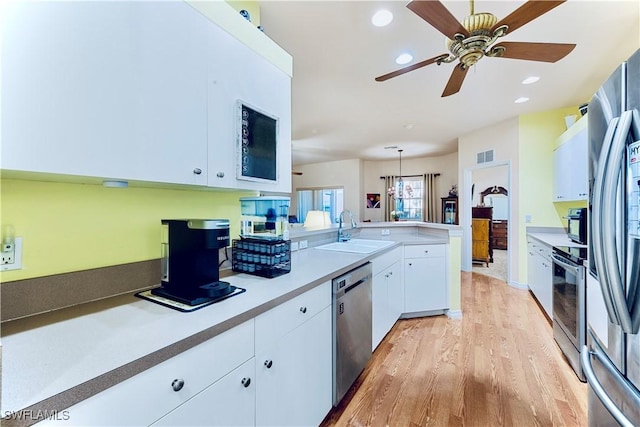 19977 Lake Vista Cir Unit 17A, Lehigh Acres, FL 33936 - kitchen with a sink, stainless steel appliances, light wood-type flooring, a peninsula, and white cabinetry