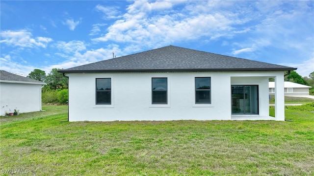 7071 Tide Cir, Labelle, FL 33935 - back of house with a lawn, stucco siding, and roof with shingles