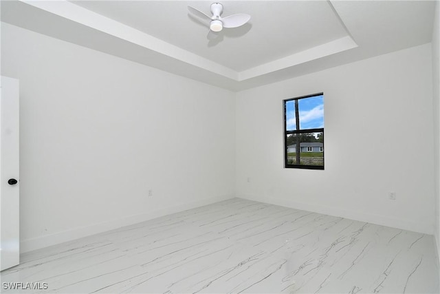 6010 Acorn Cir, Labelle, FL 33935 - spare room featuring marble look tiles, baseboards, a ceiling fan, and a raised ceiling