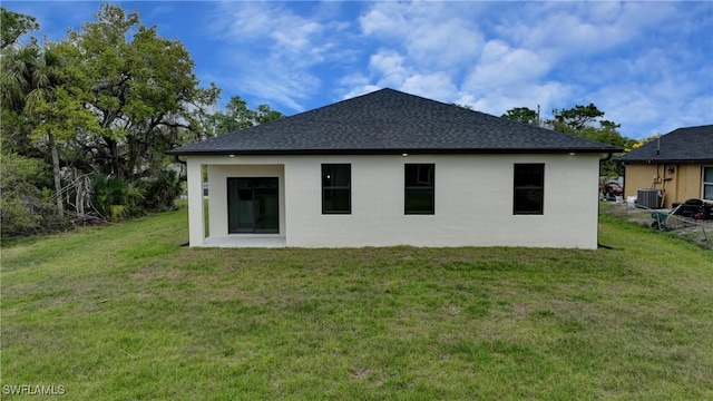 6010 Acorn Cir, Labelle, FL 33935 - back of house featuring cooling unit, a yard, stucco siding, and roof with shingles