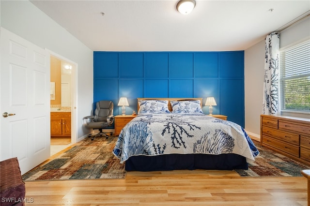 14746 Calusa Palms Dr Unit 102, Fort Myers, FL 33919 - bedroom featuring wood finished floors and a decorative wall