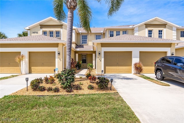 14746 Calusa Palms Dr Unit 102, Fort Myers, FL 33919 - view of front facade featuring stucco siding, concrete driveway, and a garage