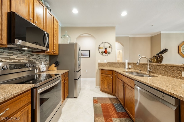 14746 Calusa Palms Dr Unit 102, Fort Myers, FL 33919 - kitchen featuring appliances with stainless steel finishes, a sink, arched walkways, ornamental molding, and tasteful backsplash