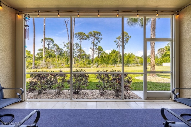 14746 Calusa Palms Dr Unit 102, Fort Myers, FL 33919 - unfurnished sunroom featuring view of wooded area