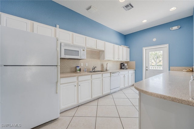 14746 Calusa Palms Dr Unit 102, Fort Myers, FL 33919 - kitchen with white appliances, tasteful backsplash, light countertops, a sink, and white cabinets