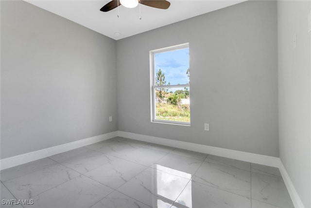 761 Fleming Ave S, Lehigh Acres, FL 33974 - empty room with marble look tiles, baseboards, a ceiling fan, and plenty of natural light