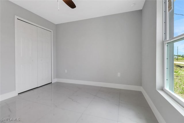 761 Fleming Ave S, Lehigh Acres, FL 33974 - unfurnished bedroom with marble finish floors, multiple windows, baseboards, and a closet