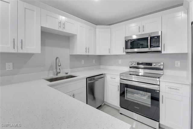 761 Fleming Ave S, Lehigh Acres, FL 33974 - kitchen with appliances with stainless steel finishes, a sink, white cabinetry, and light stone countertops
