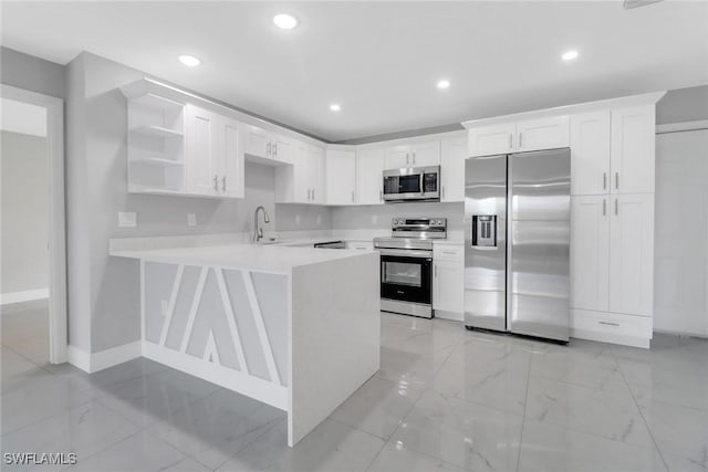 761 Fleming Ave S, Lehigh Acres, FL 33974 - kitchen featuring appliances with stainless steel finishes, open shelves, light countertops, a peninsula, and baseboards