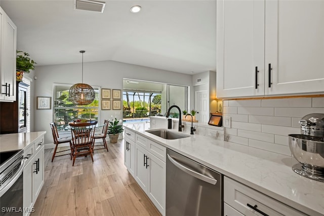 10016 Majestic Ave, Fort Myers, FL 33913 - kitchen with appliances with stainless steel finishes, a sink, healthy amount of natural light, vaulted ceiling, and light wood-style flooring
