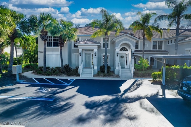 9603 Hemingway Ln Unit 4009, Fort Myers, FL 33913 - view of front of home featuring uncovered parking, a tile roof, and stucco siding