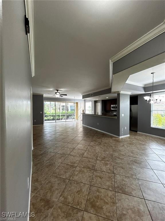 13000 Sandy Key Bnd Unit 3202, North Fort Myers, FL 33903 - spare room featuring a chandelier, ornamental molding, dark tile patterned flooring, a ceiling fan, and baseboards