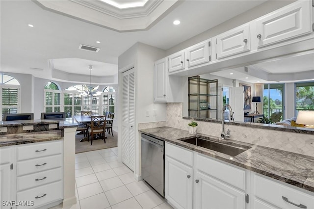 591 Audubon Blvd Unit B202, Naples, FL 34110 - kitchen with a raised ceiling, stainless steel dishwasher, dark stone countertops, white cabinets, and recessed lighting
