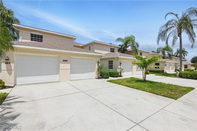 3460 W Crown Pointe Blvd Unit 101, Naples, FL 34112 - view of front facade with stucco siding, concrete driveway, and a garage