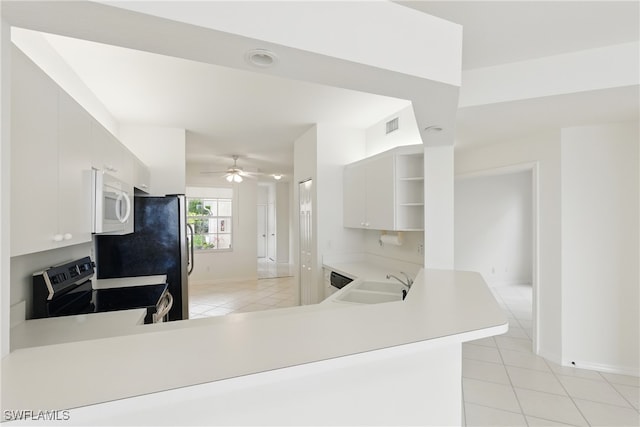 3460 W Crown Pointe Blvd Unit 101, Naples, FL 34112 - kitchen with stainless steel range with electric stovetop, a sink, white microwave, open shelves, and light tile patterned flooring