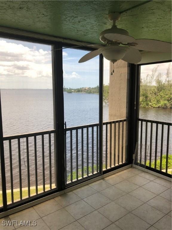 4510 N Key Dr Unit 302, North Fort Myers, FL 33903 - unfurnished sunroom featuring a water view, ceiling fan, and plenty of natural light