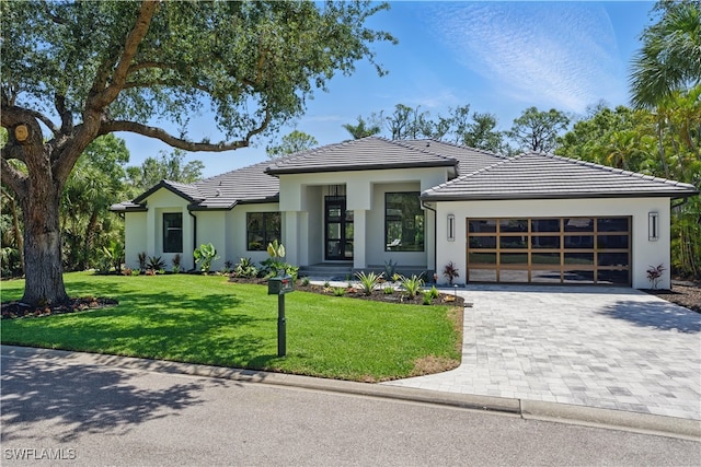 24721 Bay Bean Ct, Bonita Springs, FL 34134 - view of front of home featuring a garage, a tile roof, stucco siding, decorative driveway, and a front yard