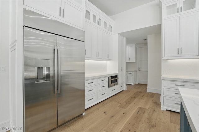 24721 Bay Bean Ct, Bonita Springs, FL 34134 - kitchen with appliances with stainless steel finishes, white cabinets, light wood-style flooring, and glass insert cabinets