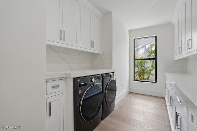 24721 Bay Bean Ct, Bonita Springs, FL 34134 - laundry area with independent washer and dryer, cabinet space, light wood-type flooring, and baseboards