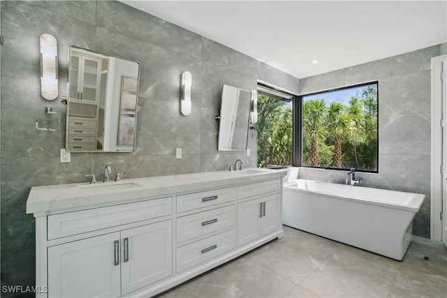 24721 Bay Bean Ct, Bonita Springs, FL 34134 - full bathroom featuring tile walls, double vanity, a soaking tub, and marble finish floors
