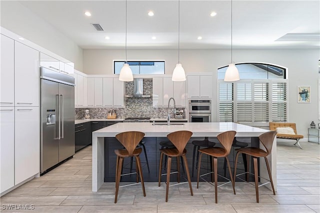 10138 Palazzo Dr, Naples, FL 34119 - kitchen with appliances with stainless steel finishes, wall chimney range hood, backsplash, light countertops, and white cabinets